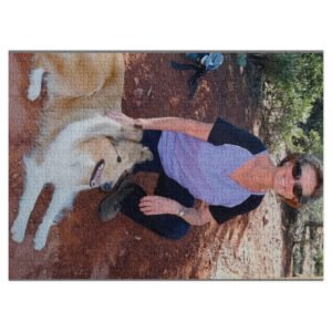 Completed jigsaw puzzle showing a person in a purple shirt outdoors with greenery in the background.
